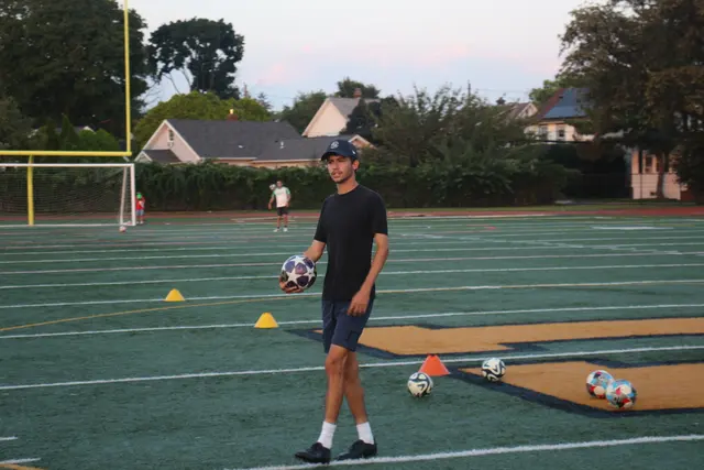 Coach Josh carrying a ball across the field