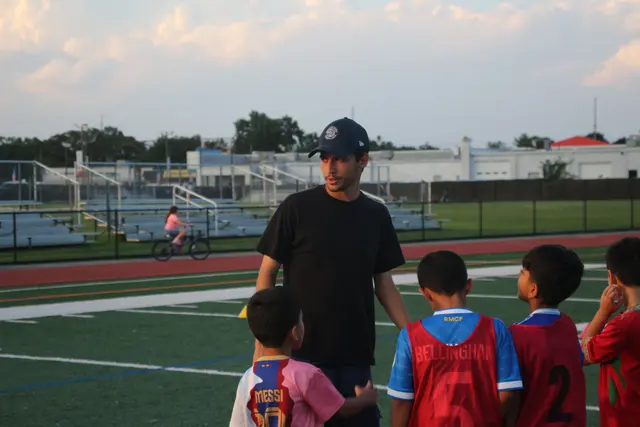 Coach Josh talking to a group of players in training bibs