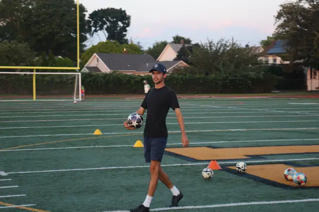 Coach Josh on the field with balls and cones set out for a drill